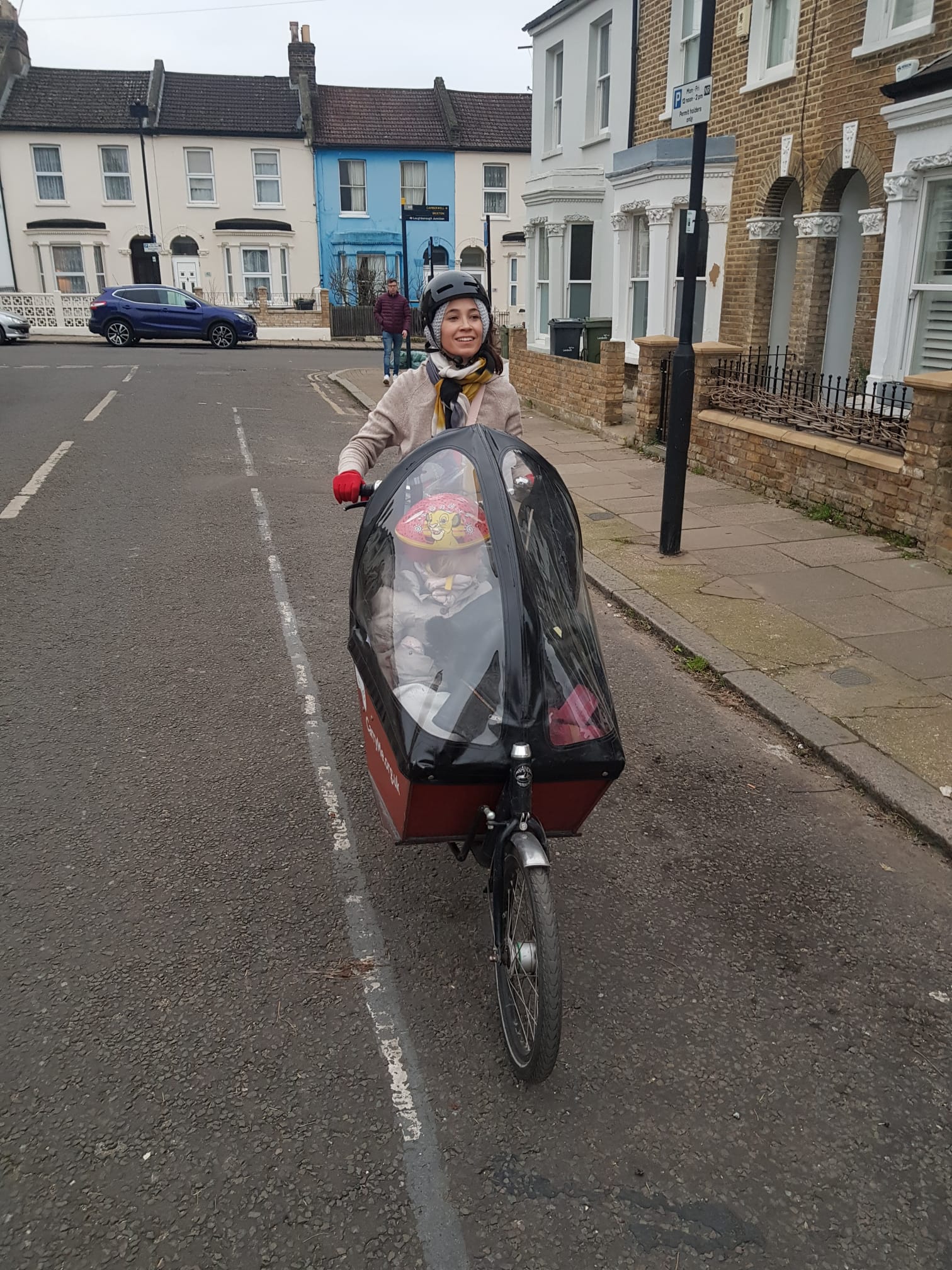 Julie Hermann keeping her daughter dry when cycling in the cargo bike!